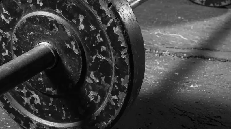 A loaded barbell with worn black bumper plates