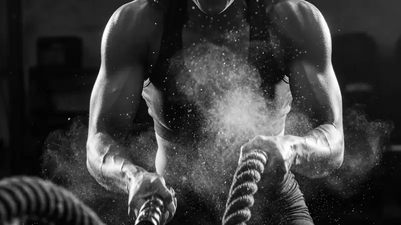 A female athlete slamming battle ropes